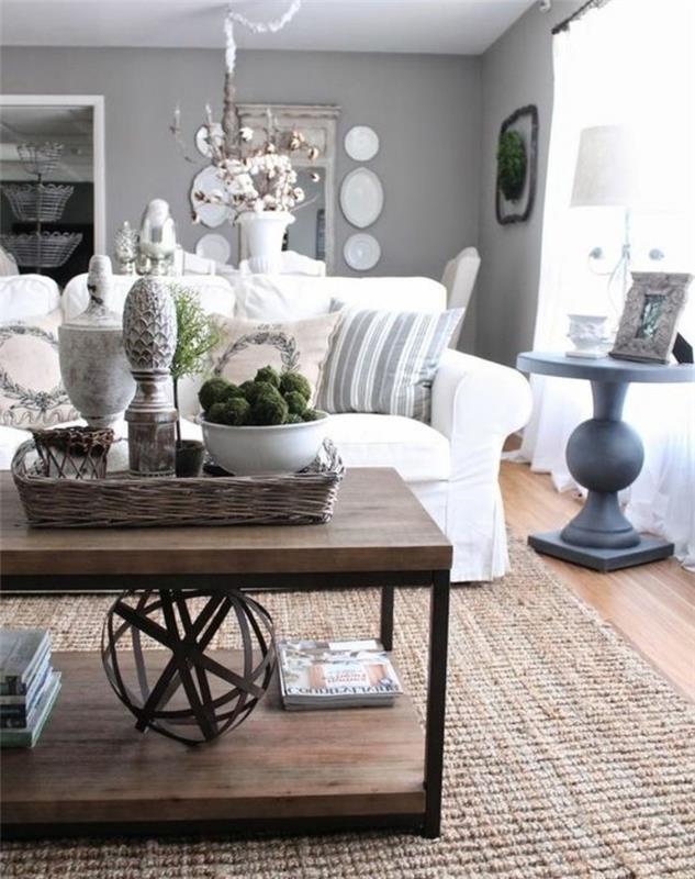 medinis kavos staliukas, balta sofa, rožinės spalvos mestos pagalvės, pilki svetainės baldai, medinės grindys