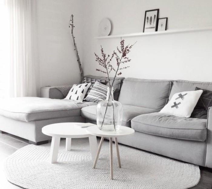 pilka kampinė sofa, baltos sienos, balti mediniai žurnaliniai staliukai, pilka ir balta svetainė