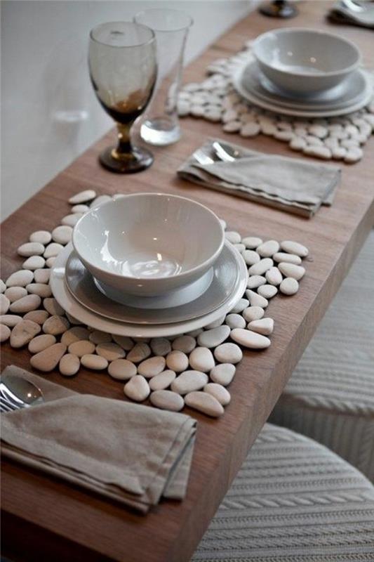 lesena miza, beli in sivi krožniki in sklede, namizni aranžmaji, sivi bombažni prtički, kozarci za vino