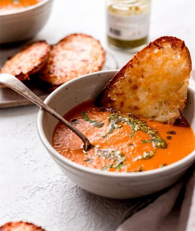 Pezzo di pane inzuppato nella vellutata, zuppe autunnali, vellutata di pomodoro